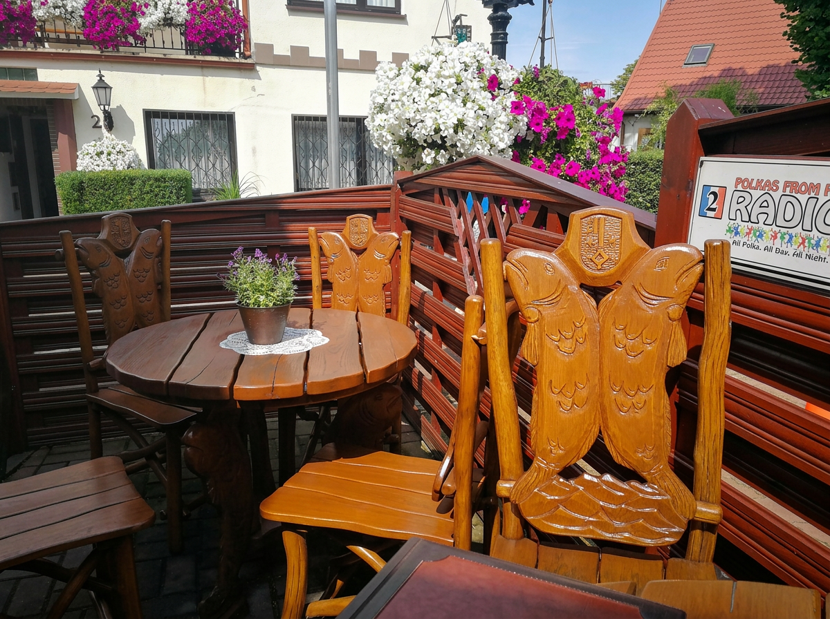 Ogródek restauracyjny z drewnianymi krzesłami z rzeźbami ryb
